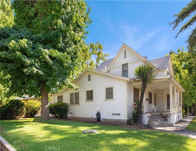 exterior space featuring covered porch and a yard