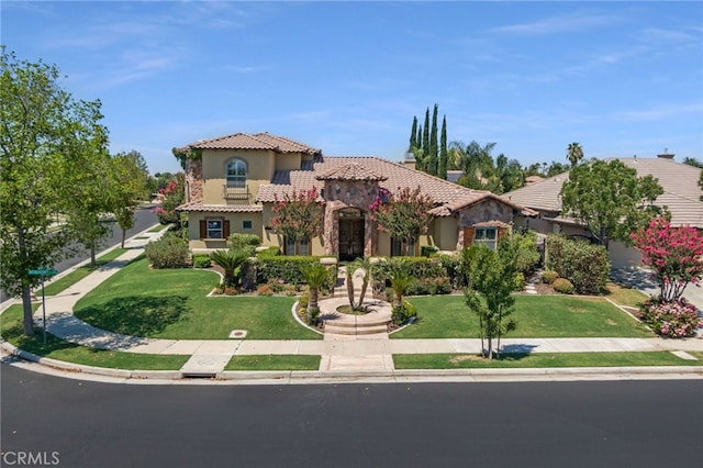 mediterranean / spanish house featuring a front lawn