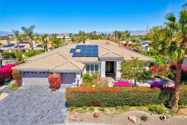 mediterranean / spanish house featuring solar panels and a garage