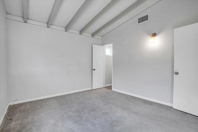 empty room featuring carpet and vaulted ceiling with beams