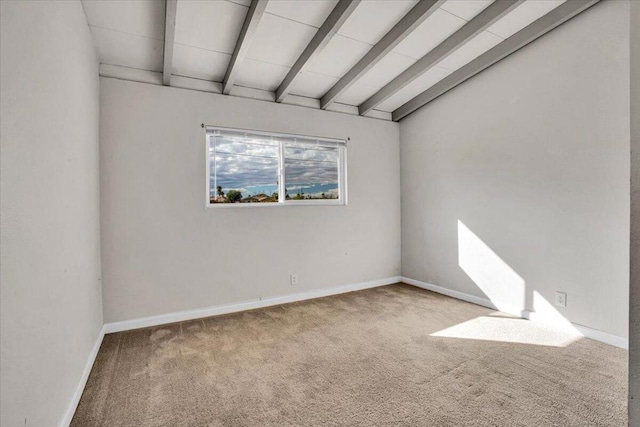 carpeted spare room featuring lofted ceiling with beams