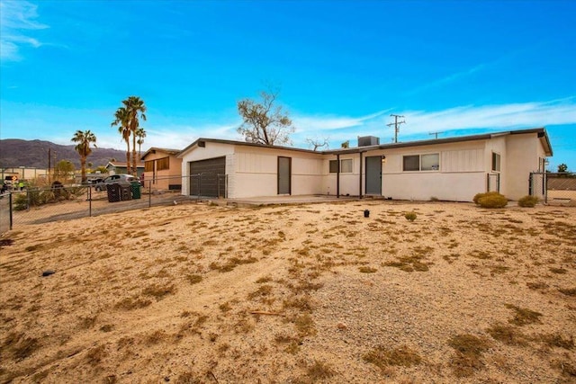 back of property with a mountain view and a garage