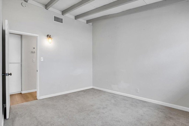 spare room with beam ceiling and carpet floors