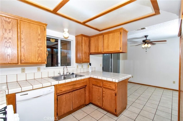 kitchen with tile counters, ceiling fan, dishwasher, and sink