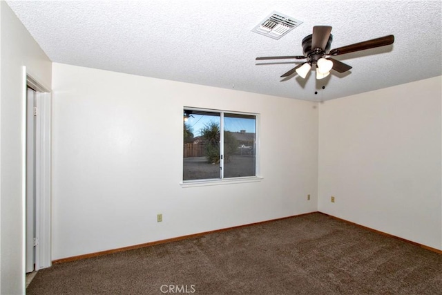 spare room with ceiling fan, a textured ceiling, and dark colored carpet