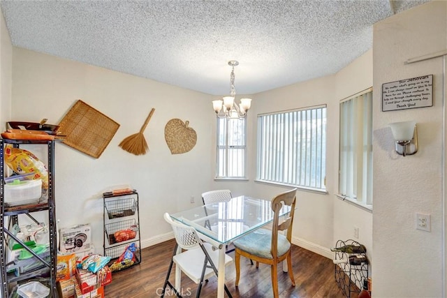 dining space with dark hardwood / wood-style flooring, a textured ceiling, and a notable chandelier