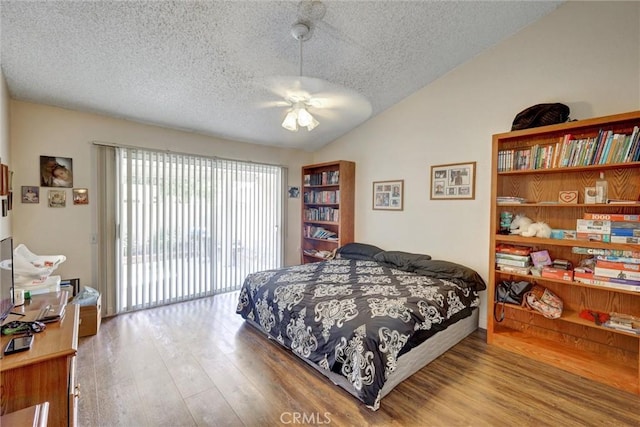 bedroom with access to exterior, ceiling fan, light hardwood / wood-style floors, a textured ceiling, and vaulted ceiling