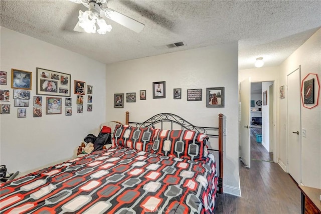 bedroom with ceiling fan, dark hardwood / wood-style floors, and a textured ceiling