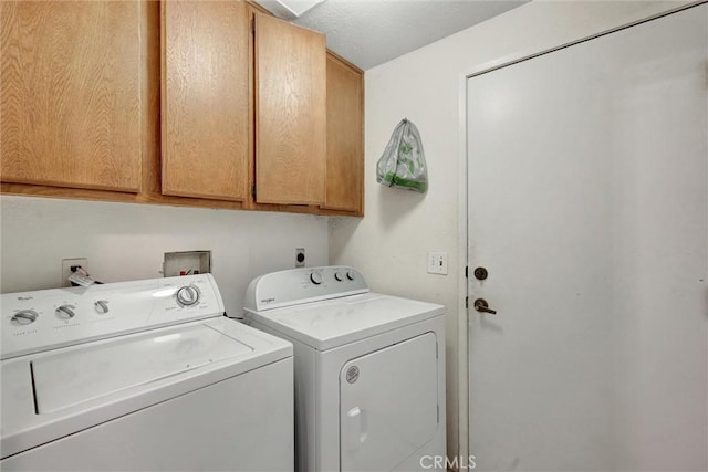 washroom with cabinet space and separate washer and dryer