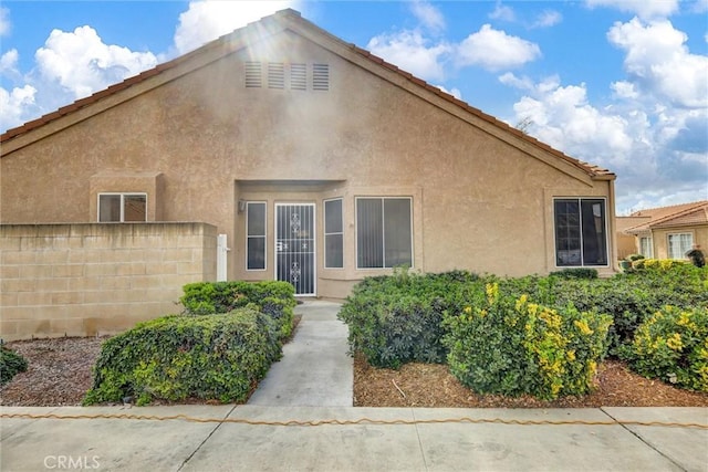 exterior space with stucco siding and fence