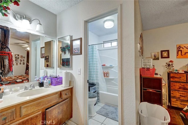 full bathroom with vanity, ceiling fan, toilet, a textured ceiling, and shower / tub combo with curtain