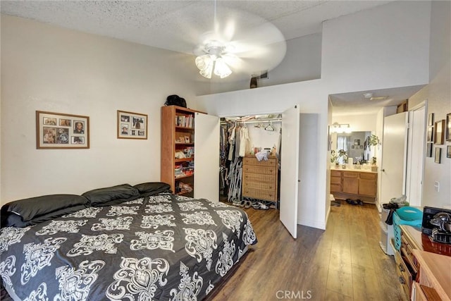 bedroom featuring connected bathroom, ceiling fan, high vaulted ceiling, dark hardwood / wood-style floors, and a closet