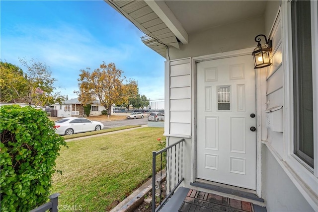 entrance to property featuring a lawn