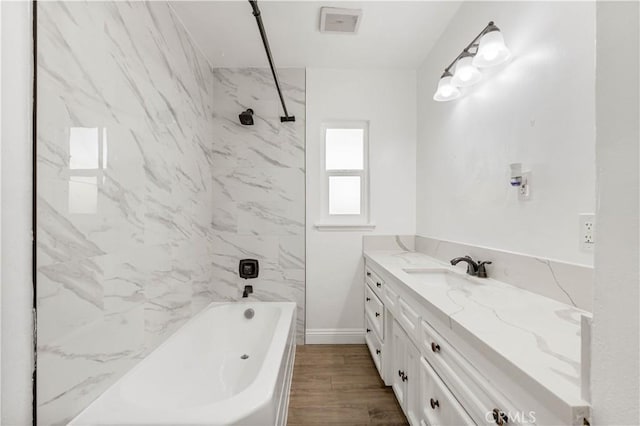 bathroom featuring vanity, tiled shower / bath combo, and hardwood / wood-style flooring