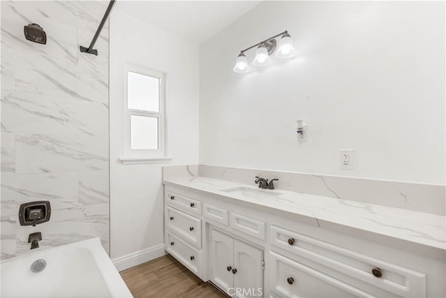 bathroom featuring hardwood / wood-style floors, vanity, and tiled shower / bath combo