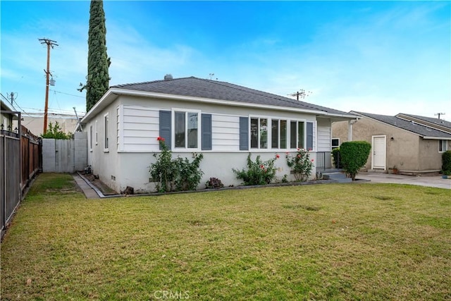 rear view of house featuring a yard