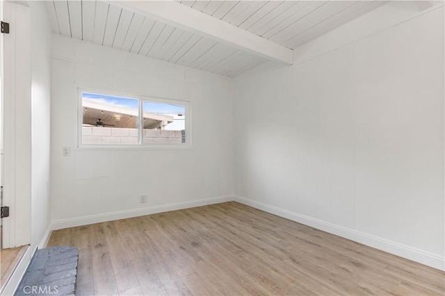 spare room featuring beam ceiling, light wood-type flooring, and wood ceiling