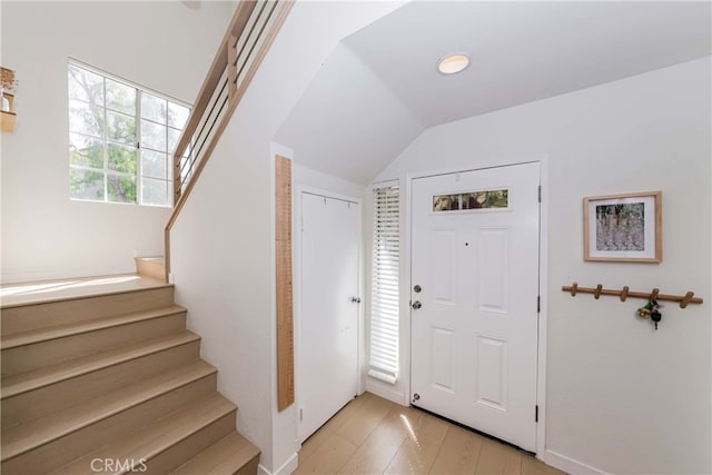 entryway featuring lofted ceiling and light wood-type flooring