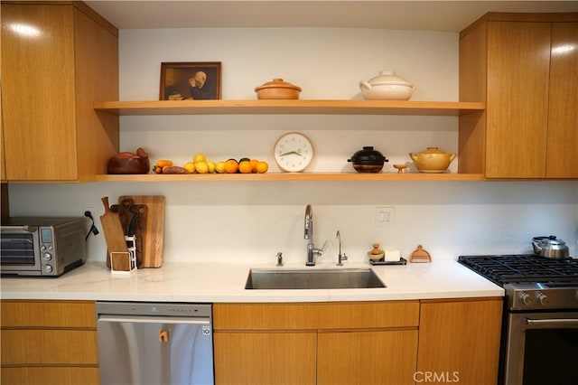 kitchen featuring sink, appliances with stainless steel finishes, and light stone counters