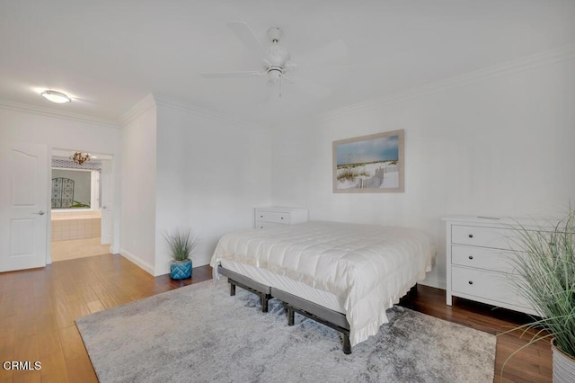 bedroom featuring connected bathroom, ceiling fan, crown molding, and dark wood-type flooring