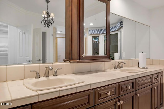 bathroom with vanity, ornamental molding, and a chandelier