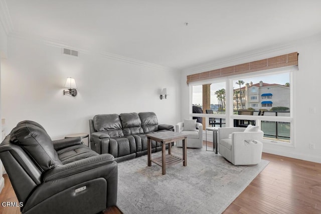 living room featuring light hardwood / wood-style flooring and crown molding