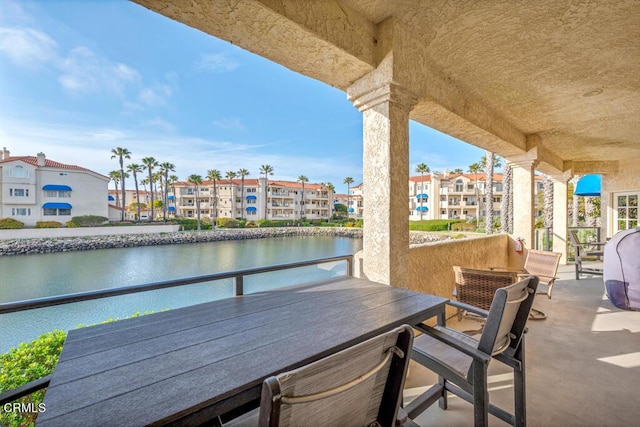 view of patio / terrace with a water view and a balcony