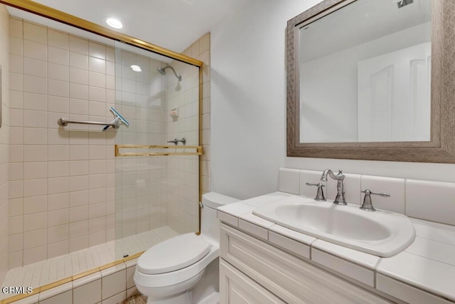 bathroom with vanity, toilet, and a shower with door