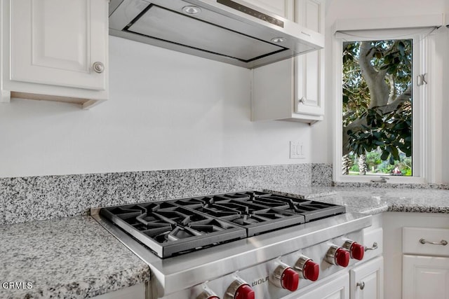 kitchen with white cabinetry, stainless steel gas stovetop, a healthy amount of sunlight, and exhaust hood