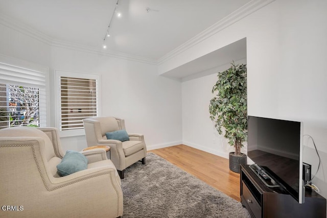 living area featuring crown molding, hardwood / wood-style floors, and track lighting