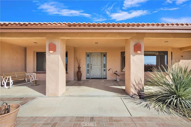 view of exterior entry featuring a patio