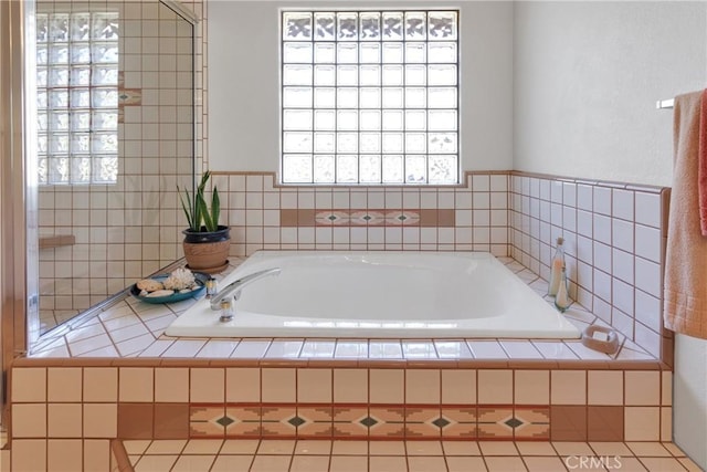 bathroom with a relaxing tiled tub