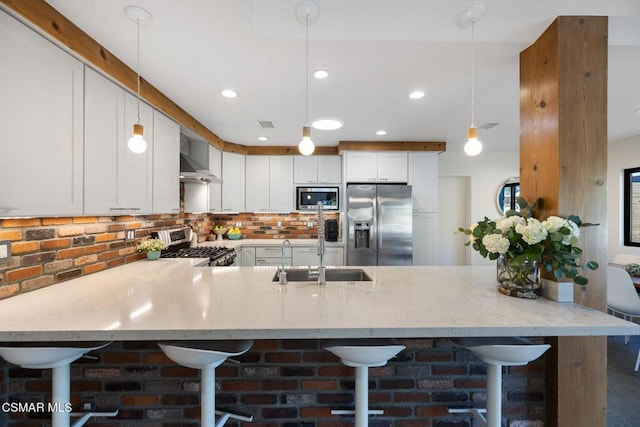 kitchen with pendant lighting, sink, a breakfast bar area, white cabinetry, and stainless steel appliances