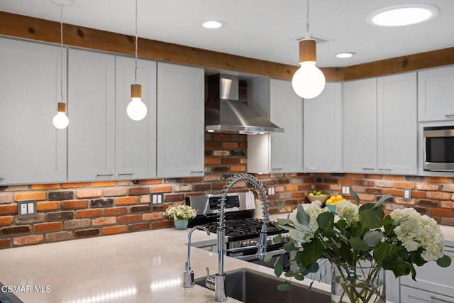 kitchen with wall chimney exhaust hood, stainless steel microwave, white cabinetry, and hanging light fixtures