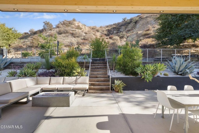 view of patio / terrace with a mountain view and an outdoor living space with a fire pit