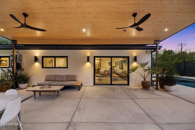 patio terrace at dusk with outdoor lounge area and ceiling fan