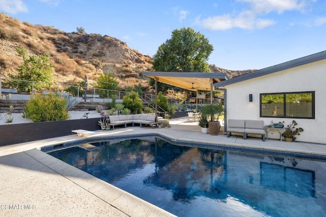 view of swimming pool featuring a patio area, a mountain view, and an outdoor hangout area