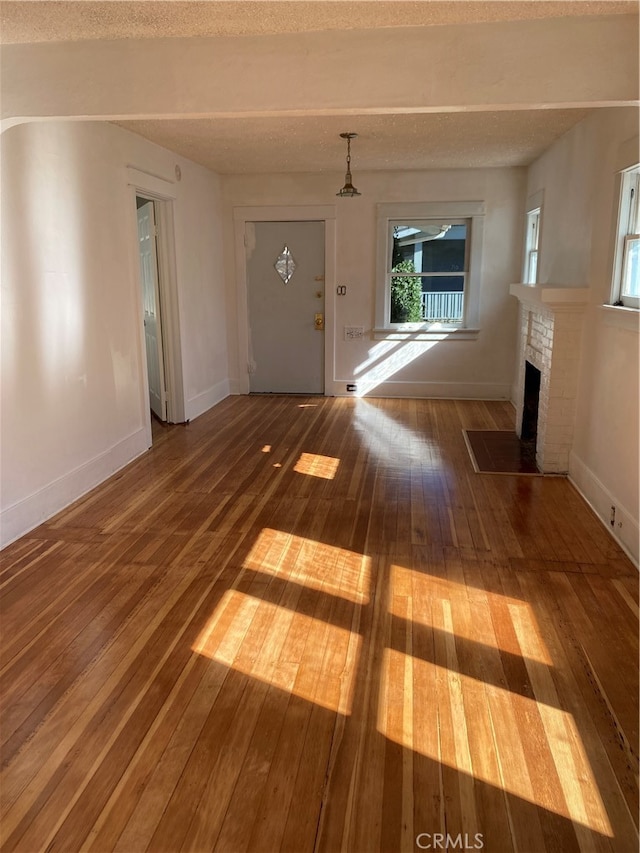 entryway featuring hardwood / wood-style floors and a brick fireplace