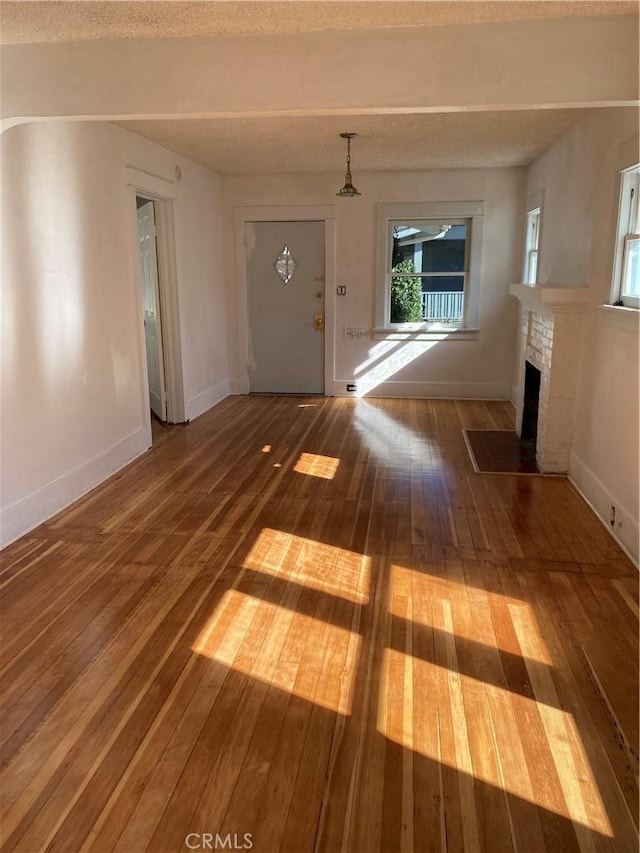 715 Hope Ct, South Pasadena, CA 91030 - unfurnished living room with hardwood / wood-style floors, a brick fireplace, and baseboards