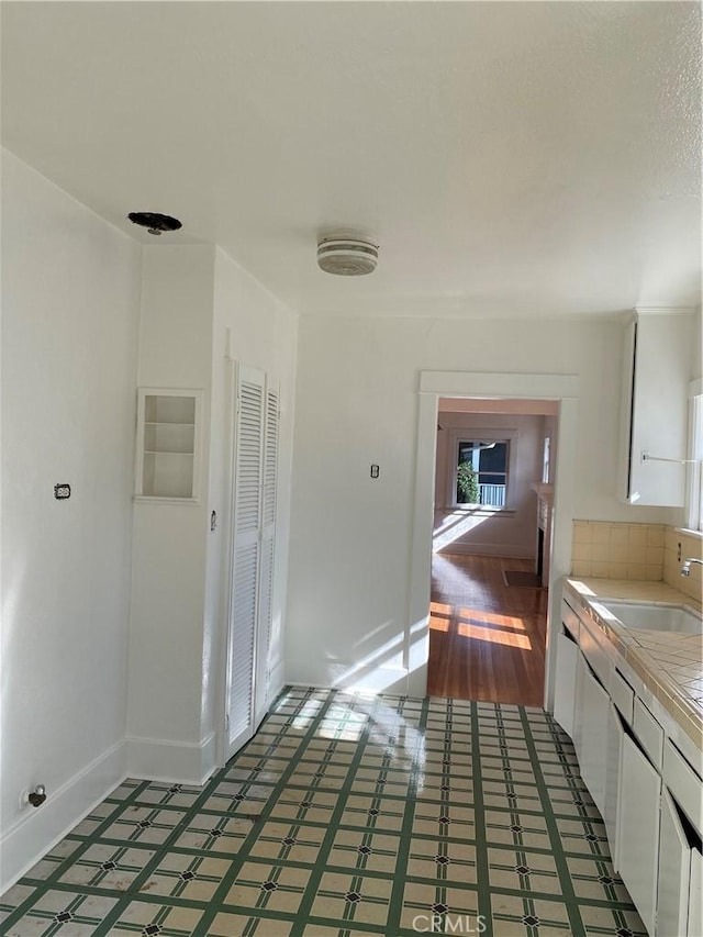 715 Hope Ct, South Pasadena, CA 91030 - kitchen featuring tile counters, white cabinets, a sink, light floors, and baseboards