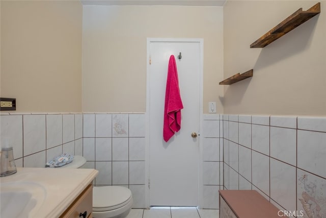 bathroom with tile walls, tile patterned floors, vanity, and toilet