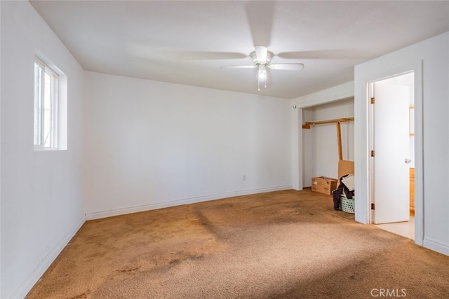 unfurnished room with ceiling fan and carpet