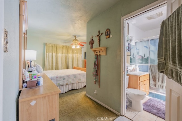 bedroom with ceiling fan, sink, connected bathroom, and a textured ceiling