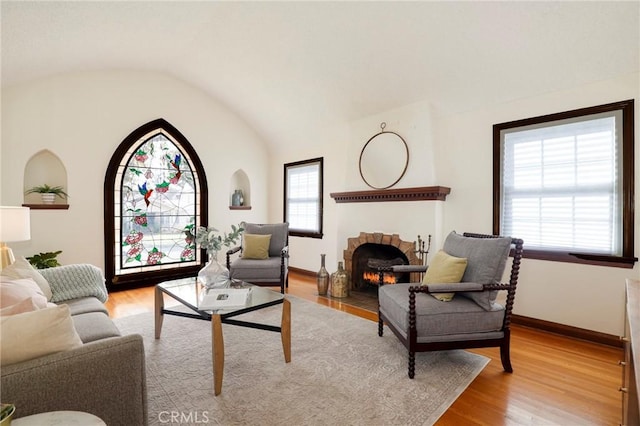 living room featuring plenty of natural light, light hardwood / wood-style floors, and vaulted ceiling