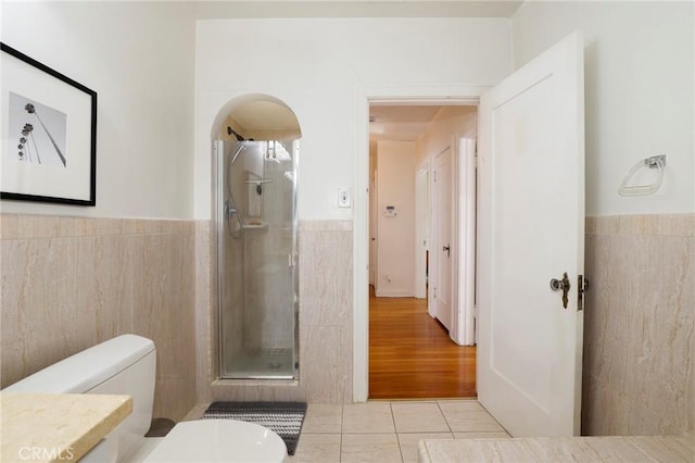 bathroom featuring tile patterned floors, toilet, an enclosed shower, and vanity