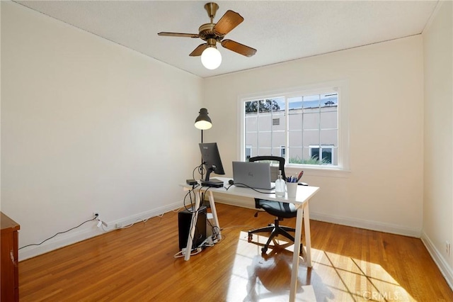 home office with light wood-type flooring and ceiling fan