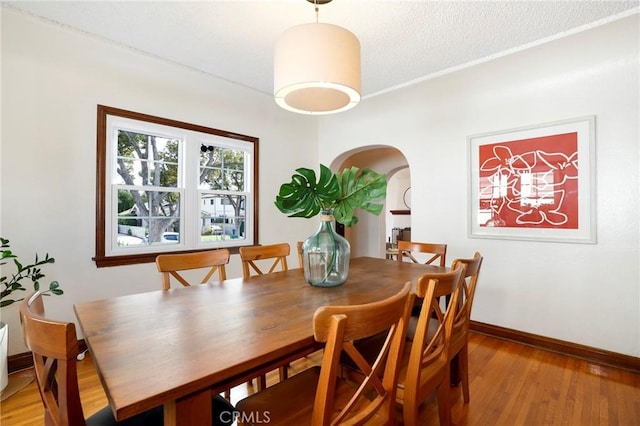 dining space with a textured ceiling and light wood-type flooring