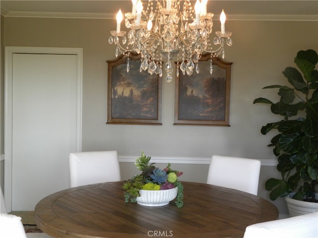 dining space with ornamental molding and a notable chandelier