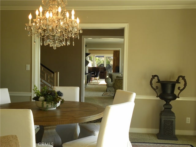 dining area with ornamental molding, carpet flooring, and an inviting chandelier