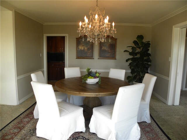 dining room featuring crown molding, a notable chandelier, and carpet flooring